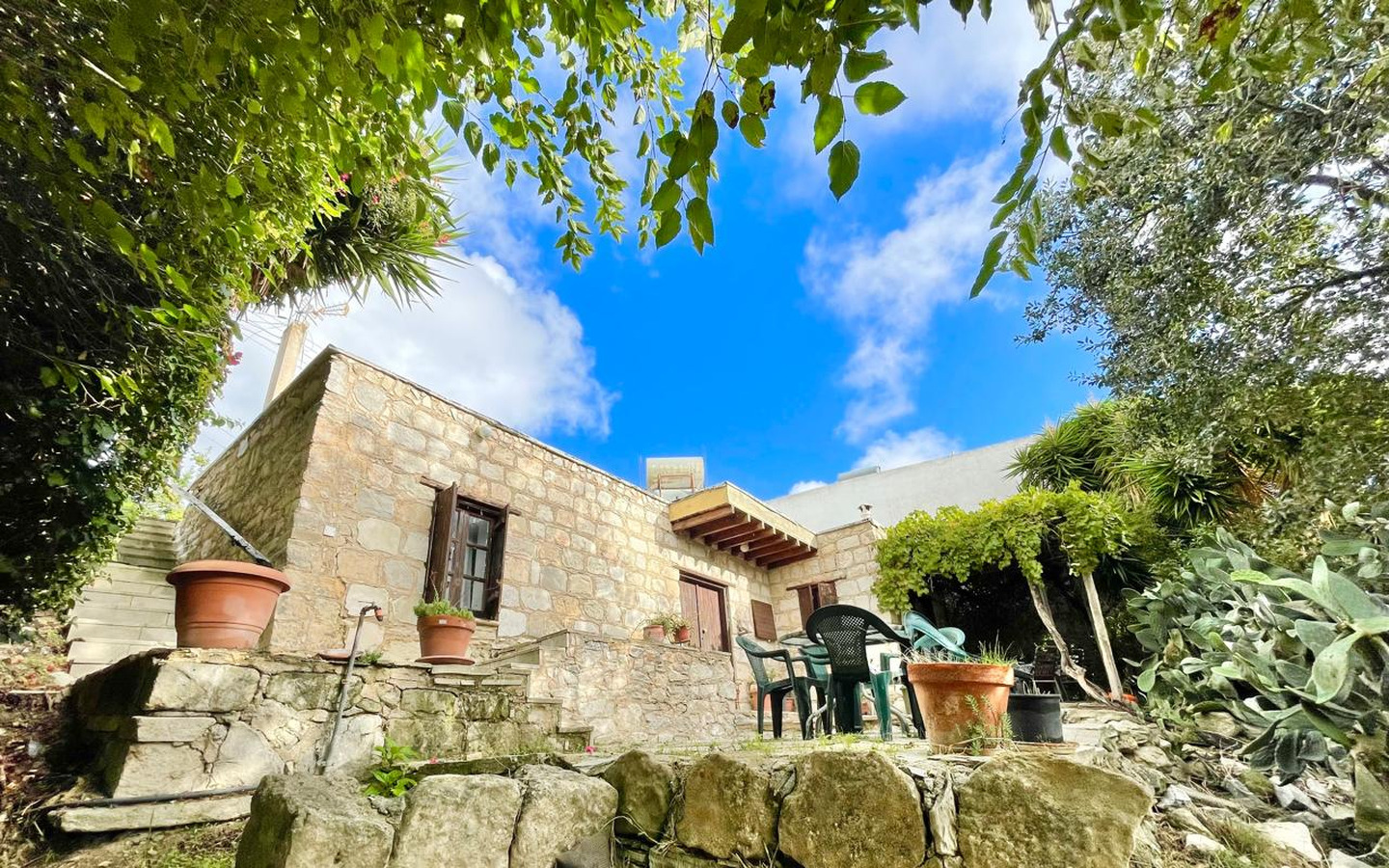 01_Exterior_stone-house-for-sale-paphos-cyprus One-bedroom stone cottage with a fireplace and a beautiful green garden