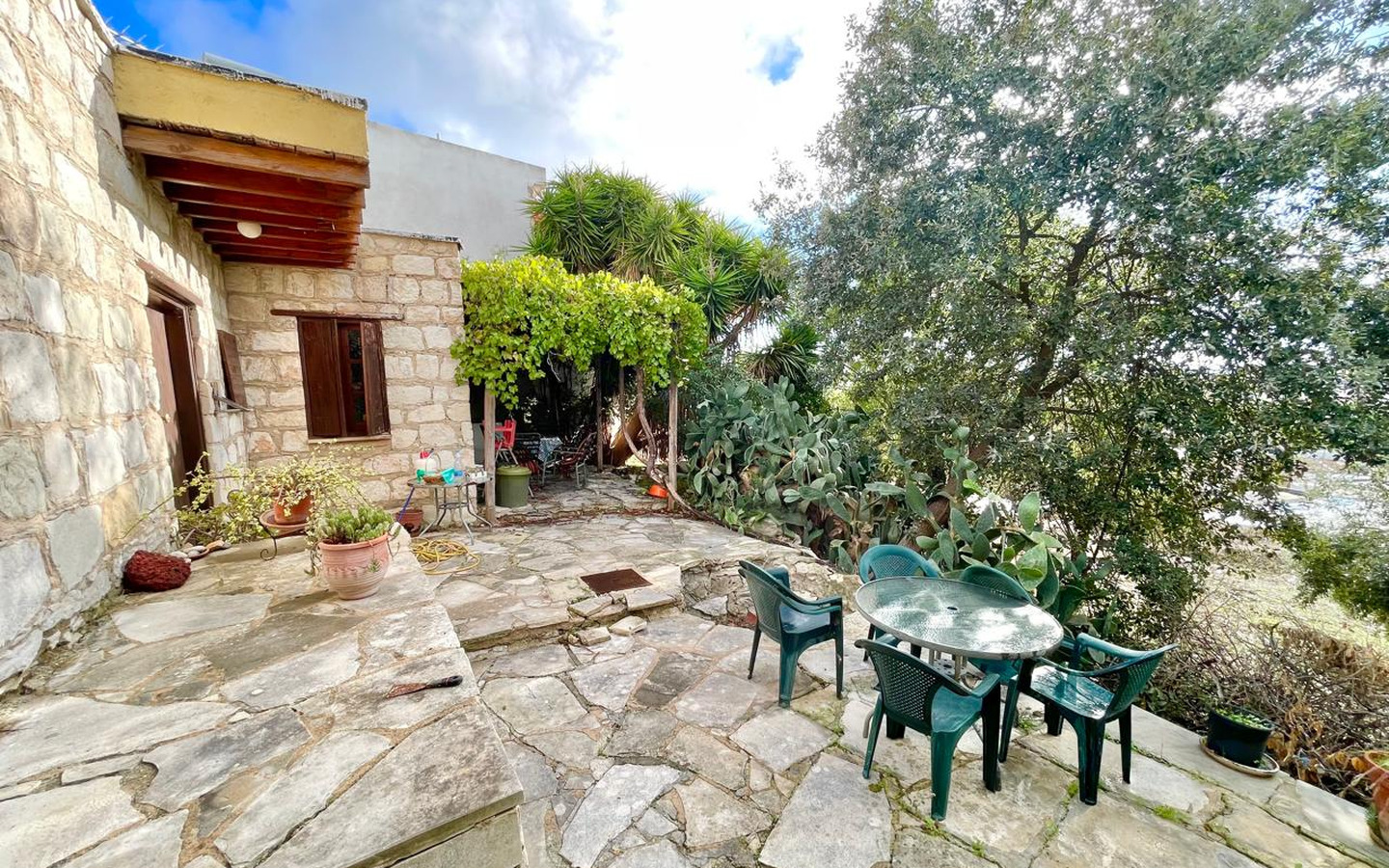03_Exterior_stone-house-for-sale-paphos-cyprus One-bedroom stone cottage with a fireplace and a beautiful green garden