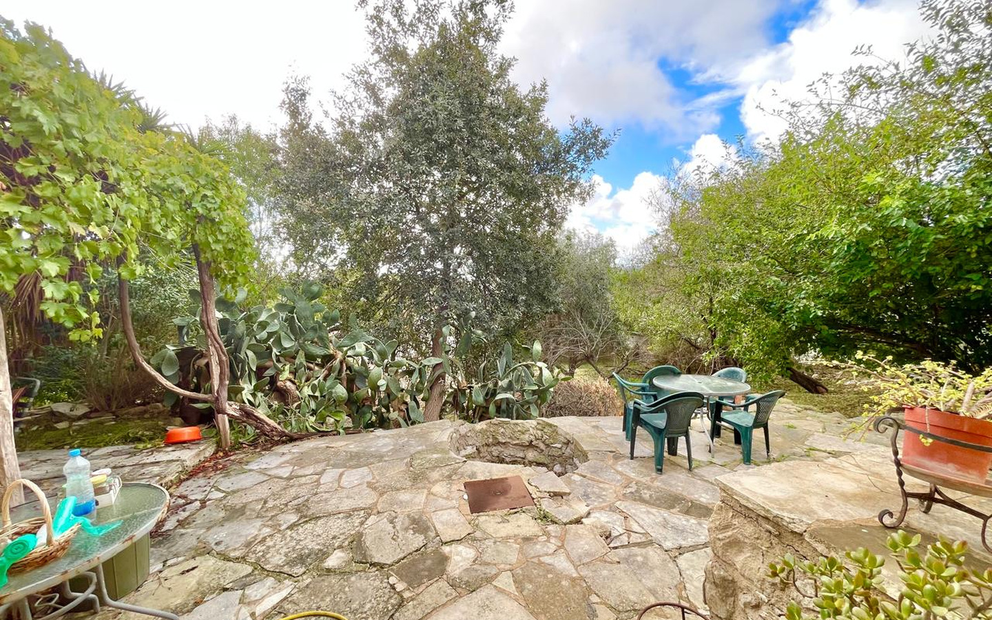 04_Exterior_stone-house-for-sale-paphos-cyprus One-bedroom stone cottage with a fireplace and a beautiful green garden