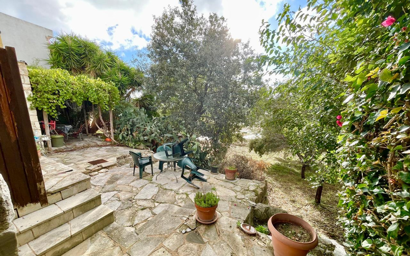 05_Exterior_stone-house-for-sale-paphos-cyprus One-bedroom stone cottage with a fireplace and a beautiful green garden