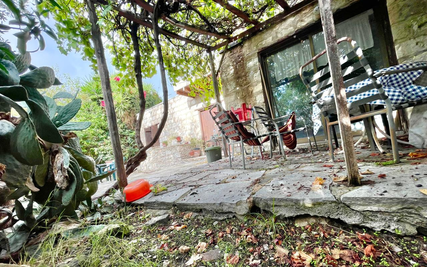 07_Exterior_stone-house-for-sale-paphos-cyprus One-bedroom stone cottage with a fireplace and a beautiful green garden